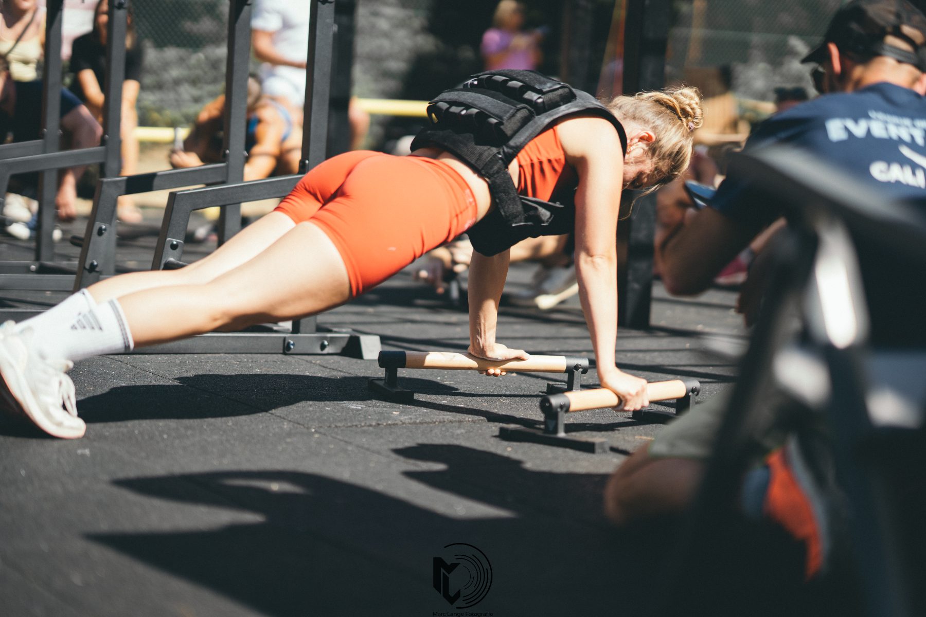 Push-ups mit Gewichtsweste an den Parallettes