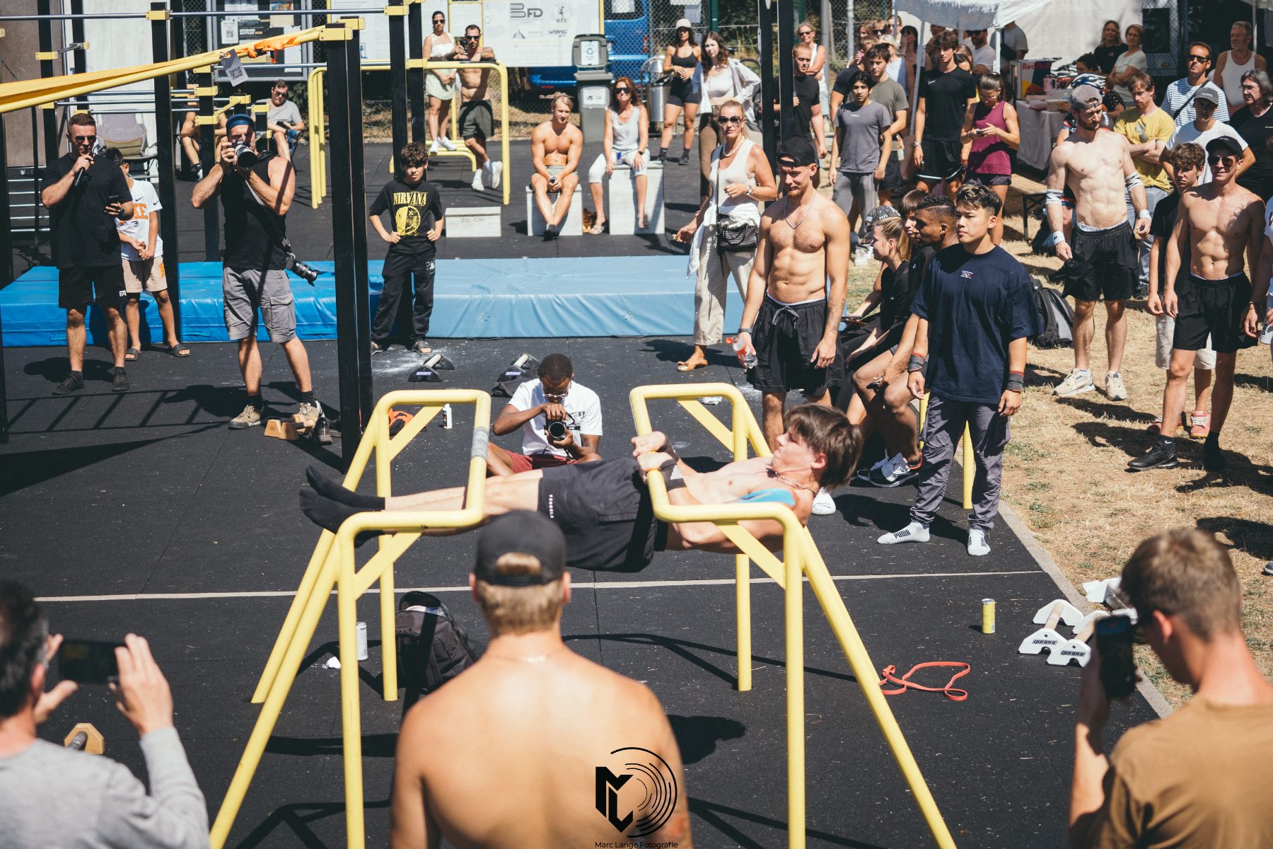 Leg Raises an den Parallettes vor Publikum und Fotografen